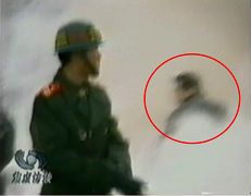 CCTV“自焚”节目慢动作分析-4：一名身穿大衣的男子正好站在出手打击的方位，仍然保持着一秒钟前用力打击的姿势